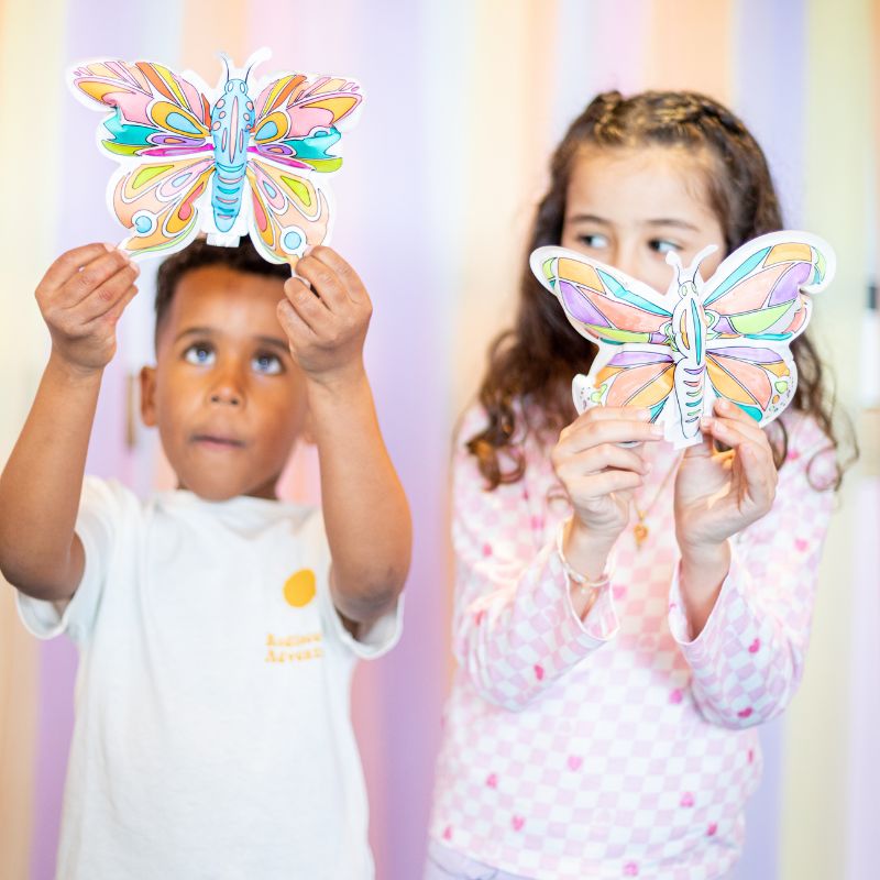 Crianças seguram borboletas de papel pintadas coloridas