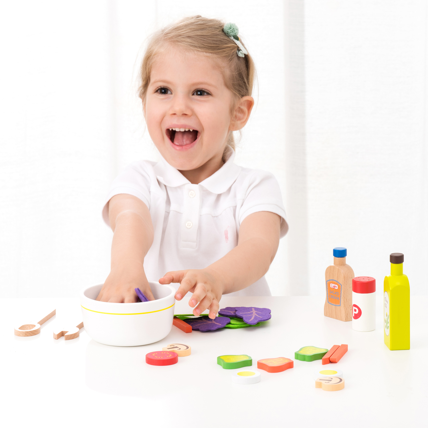 Criança brincando com brinquedos de cozinha e alimentos de madeira coloridos
