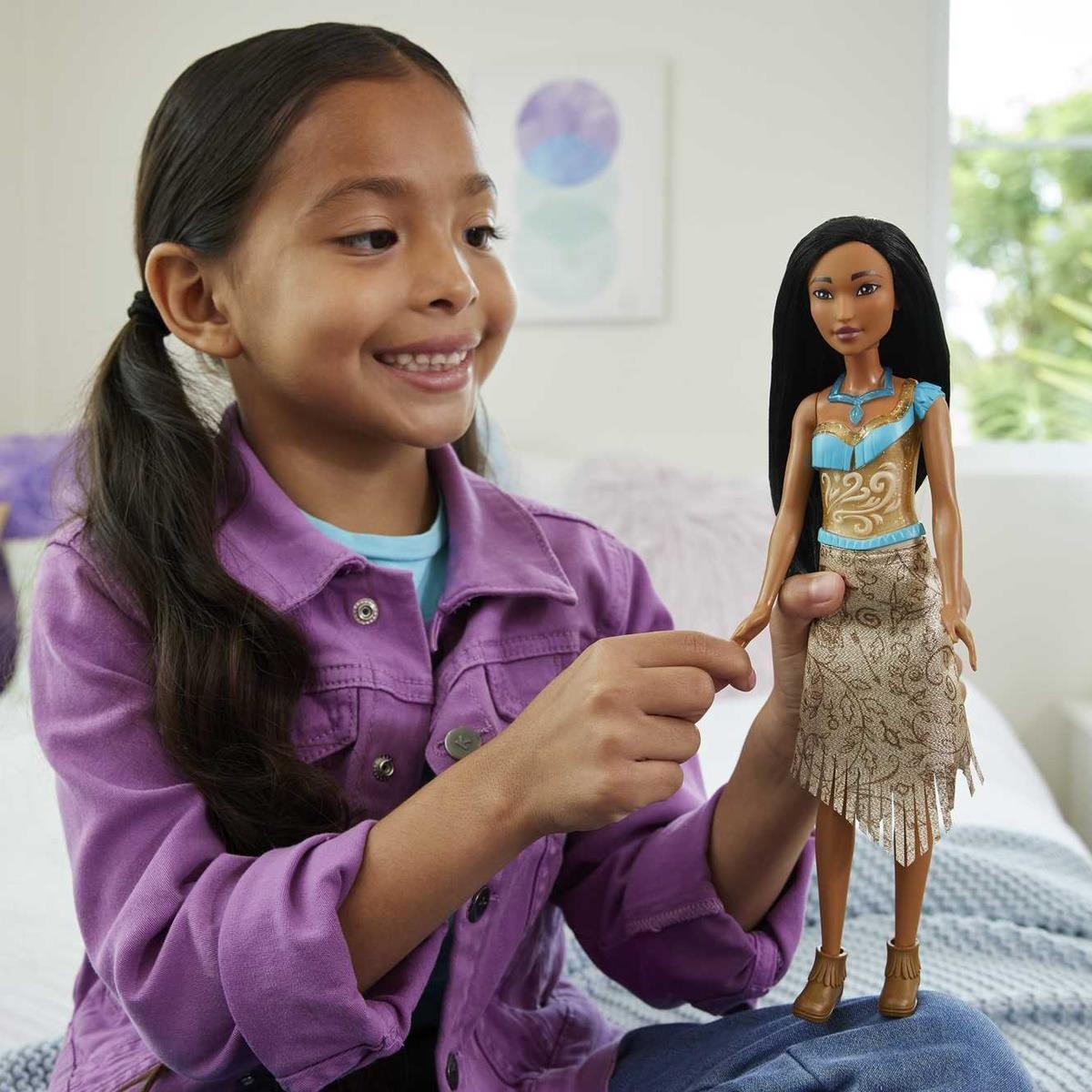 Criança a segurar boneca Morena com roupa azul clara e bege