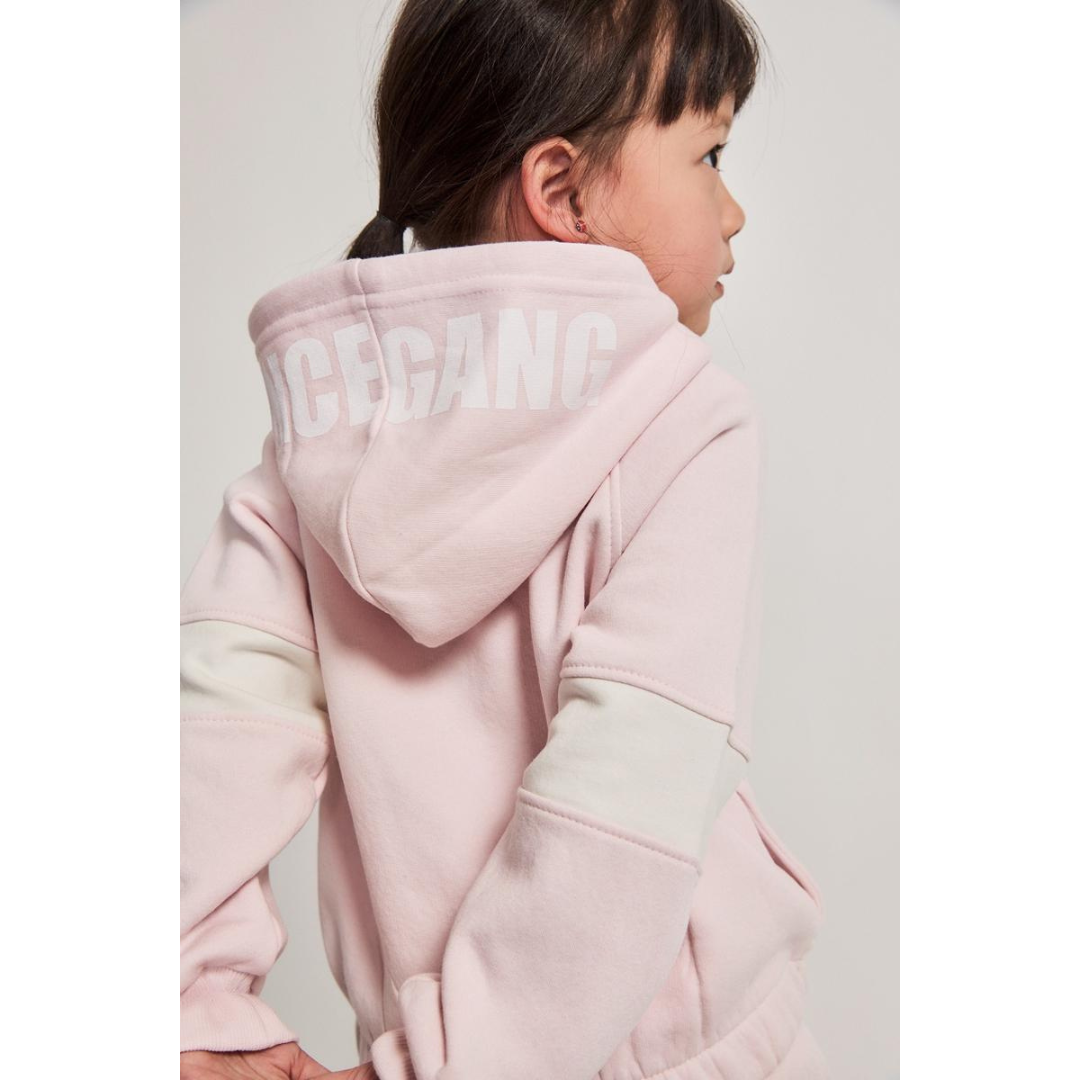 Criança com casaco rosa claro com capuz e texto ICEGANG nas costas