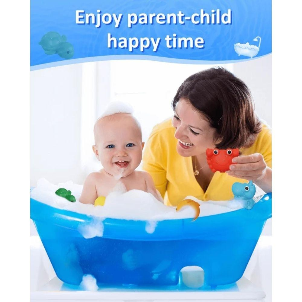 Bebé numa banheira azul com espuma e mulher a segurar brinquedos de banho coloridos
