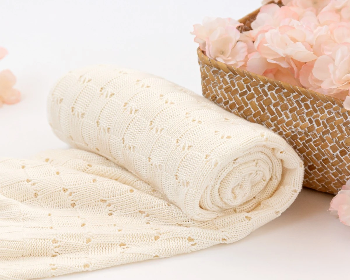 Cobertor branco creme tricotado com padrão de losangos