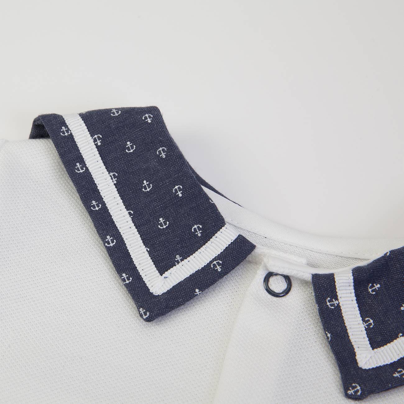Gola branca com detalhes azul-marinho e âncoras em peça de roupa branca