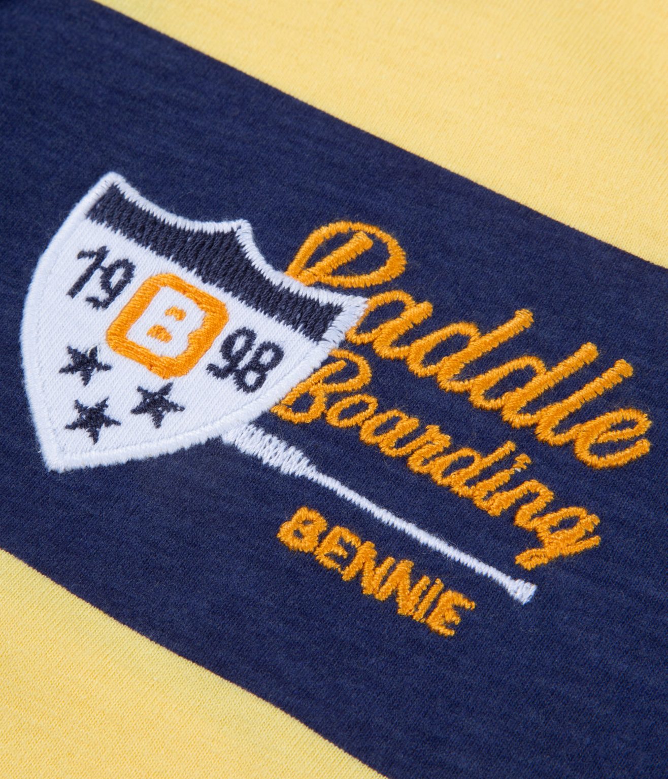 Pormenor de tecido com bordado Paddle Boarding