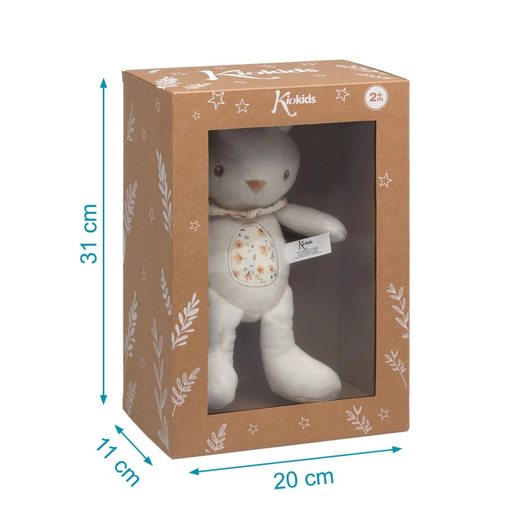 Ursinho de peluche branco em caixa castanha KioKids com padrão floral e janela transparente
