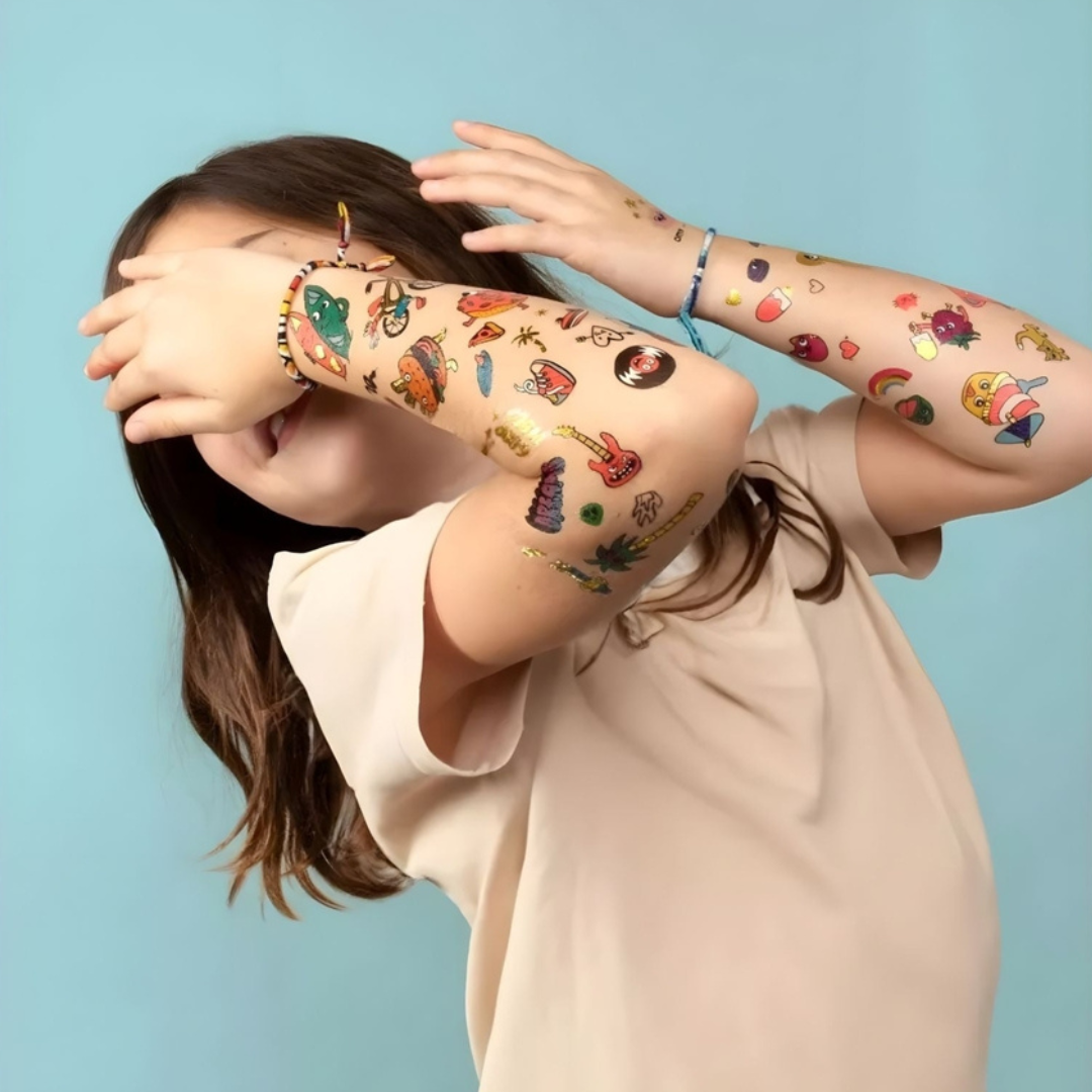Criança com tatuagens temporárias coloridas nos braços.