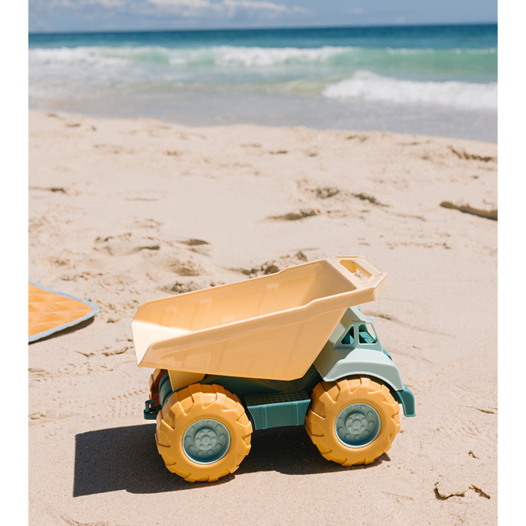 Carrinho de brinquedo para areia amarelo e azul na praia