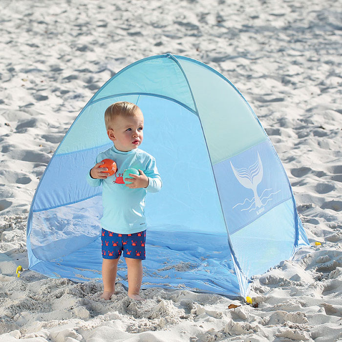 Tenda de praia azul clara com bebé em areia