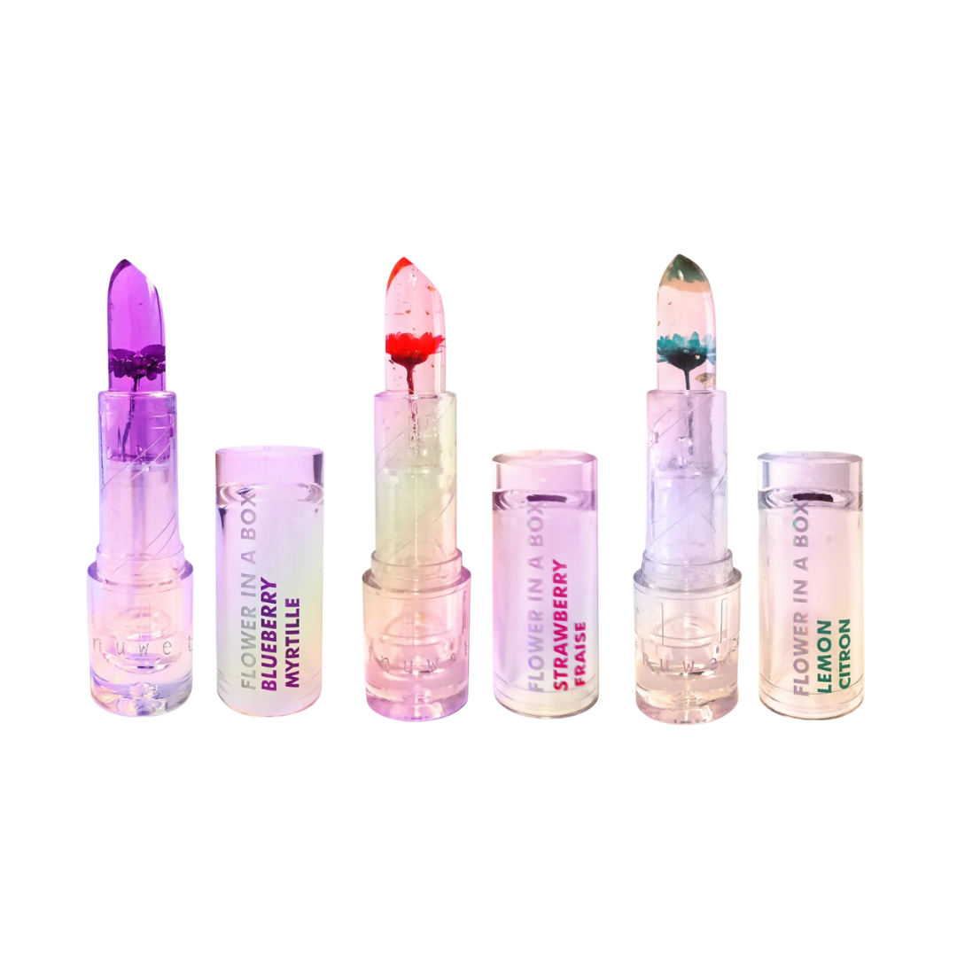 Três batons transparentes coloridos com flores no interior e embalagens translúcidas etiquetadas