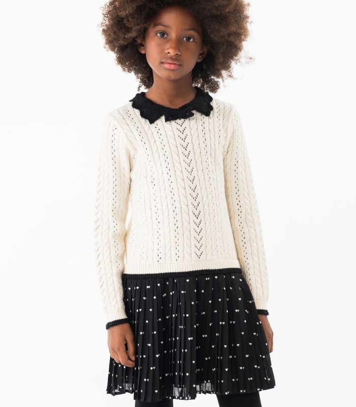 Camisola branca de malha com gola preta e saia preta plissada com corações brancos