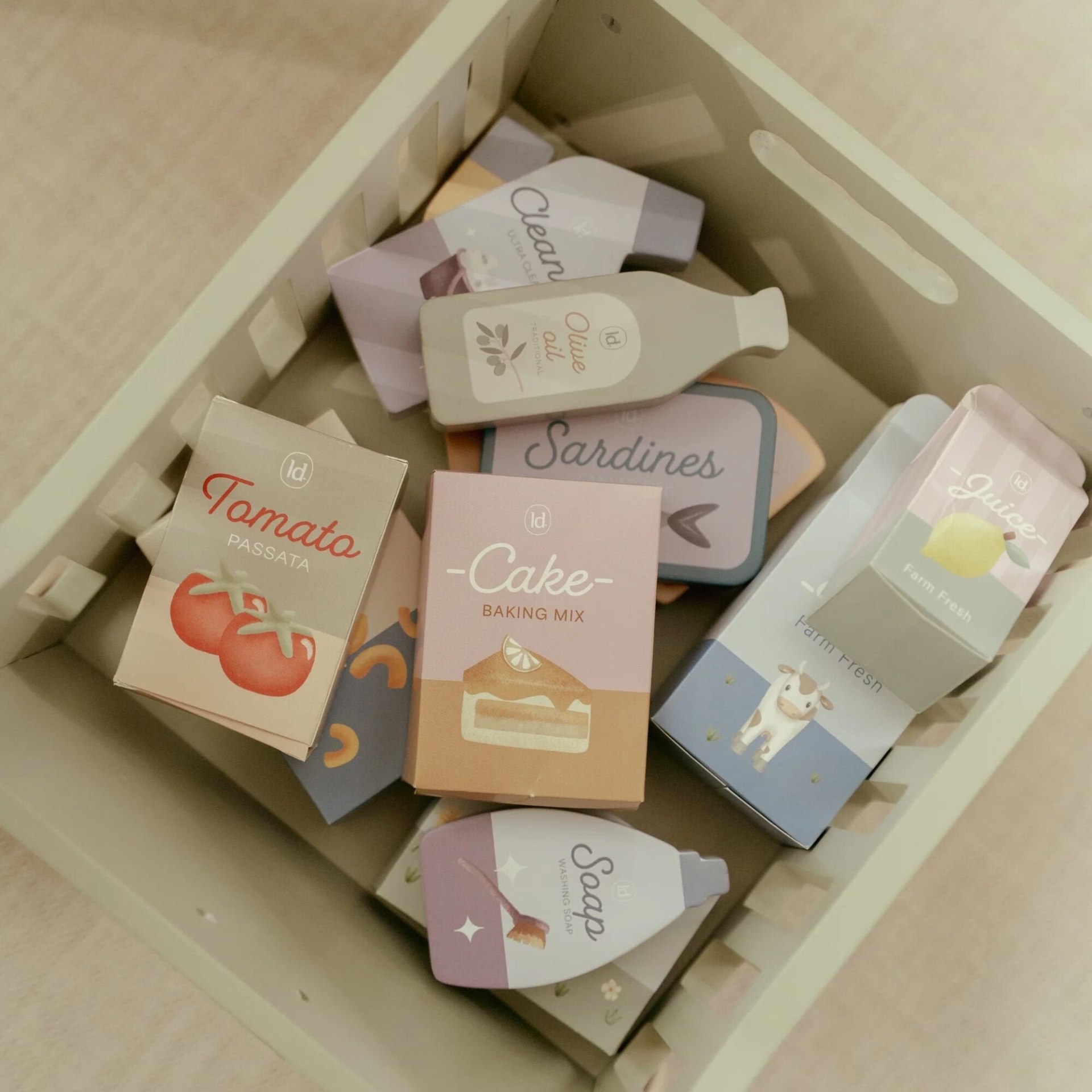 Caixa bege com miniaturas de embalagens de alimentos e produtos de papel/cartão coloridos e ilustrados.