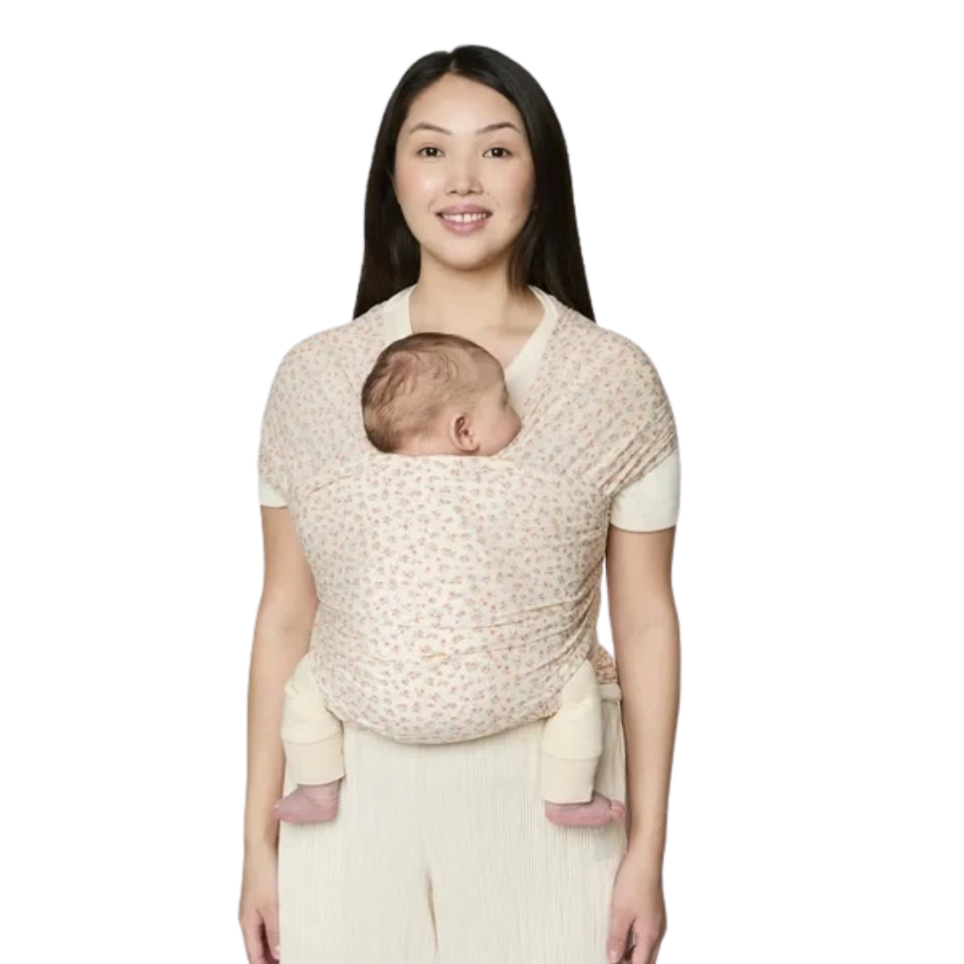 Mulher com bebé numa faixa porta-bebé com padrão floral