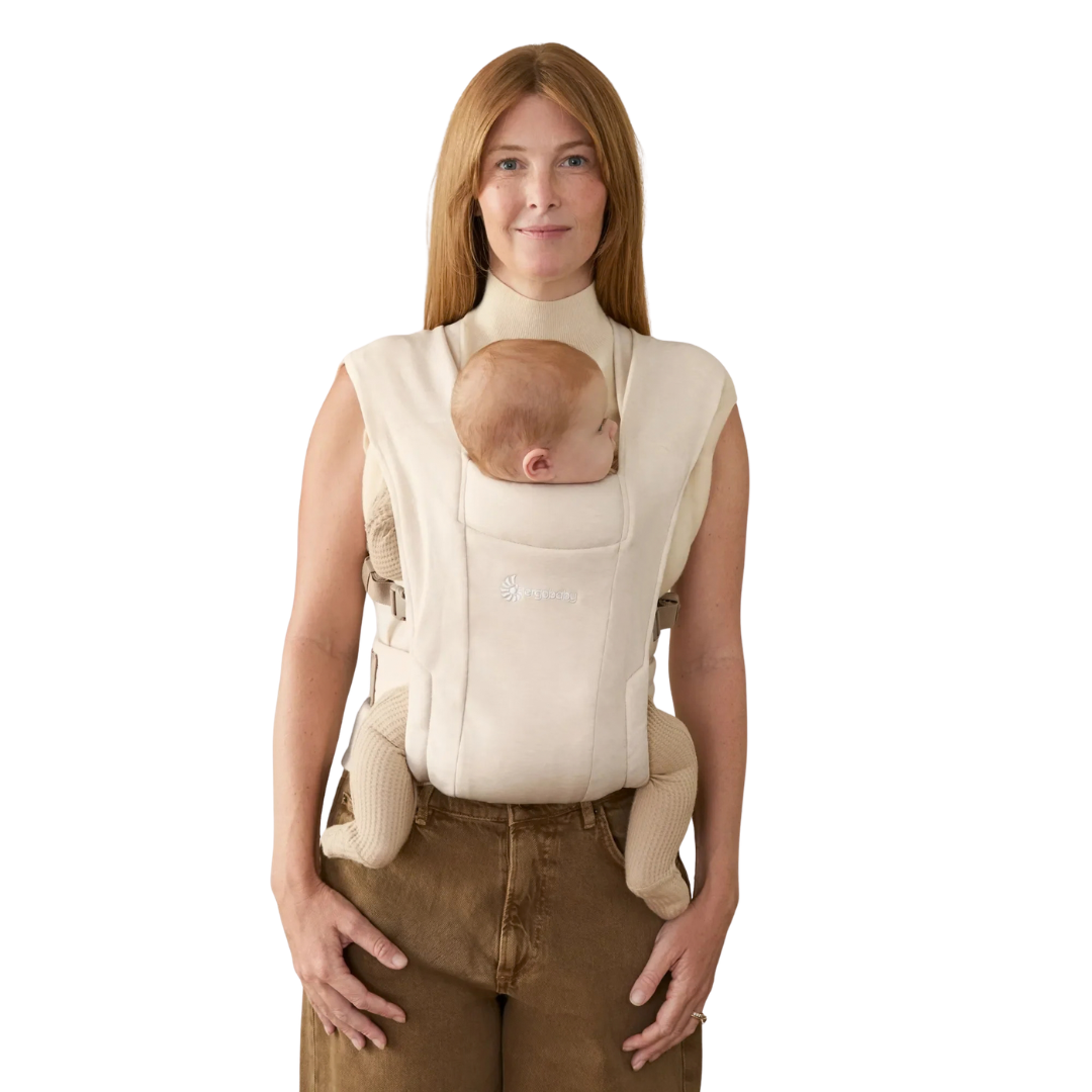 Porta-bebés ergonómico bege com bebé em mulher vestida casual