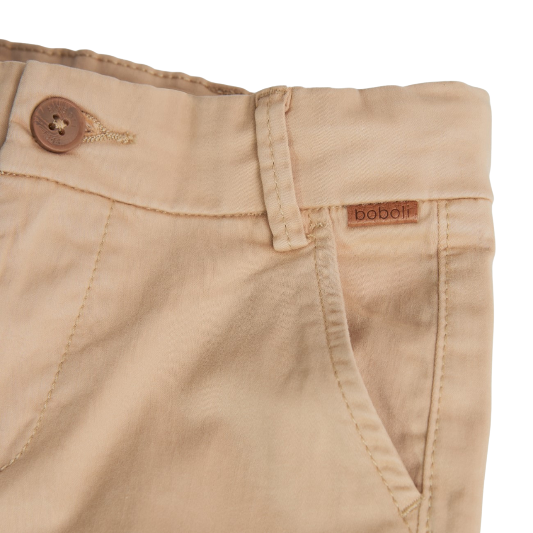 Calças bege claras com botão castanho e etiqueta boboli