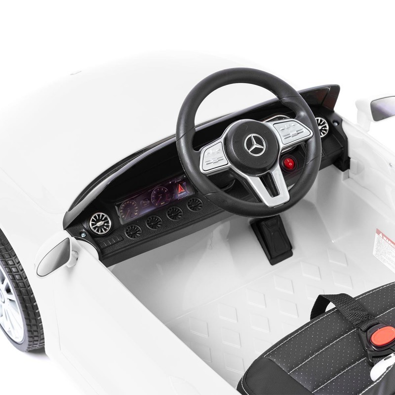 Interior de carro de criança branco com volante preto e assento com cinto vermelho