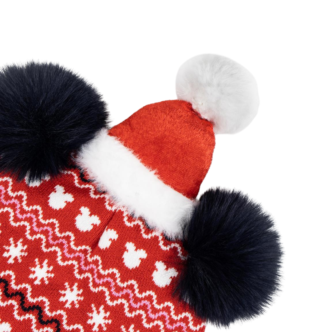 Gorro de malha vermelho com padrão branco e rosa, pompons pretos e branco, borda branca felpuda.