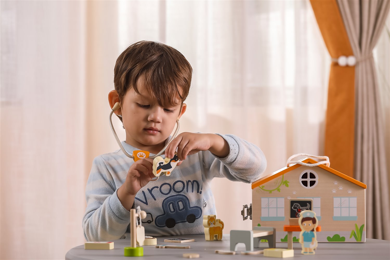 Criança a brincar com brinquedo de veterinário de madeira e casa toy