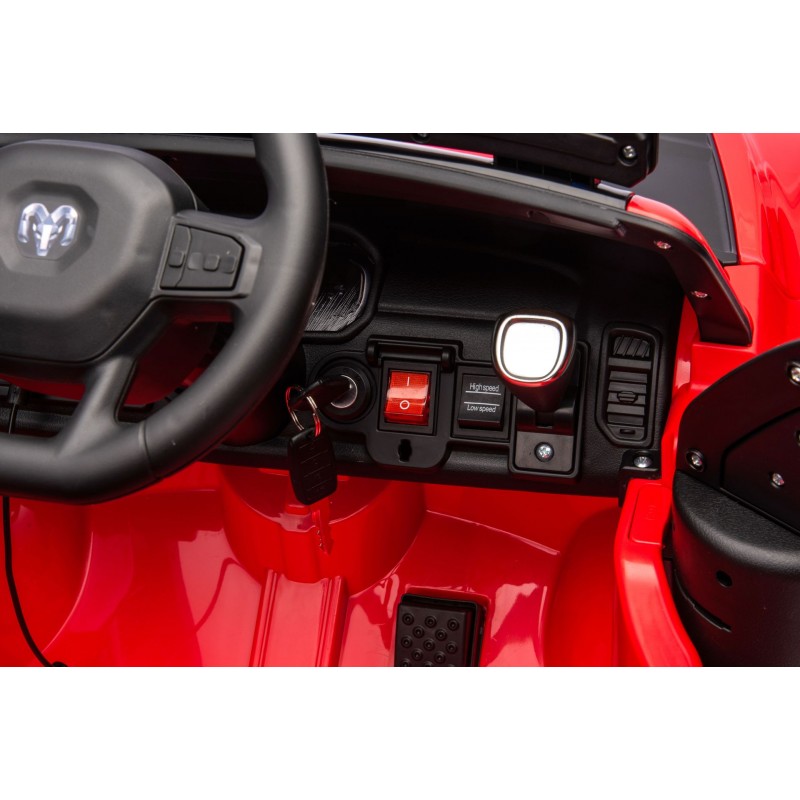 Interior de carro vermelho de brinquedo com volante, botões, chave e pedal preto