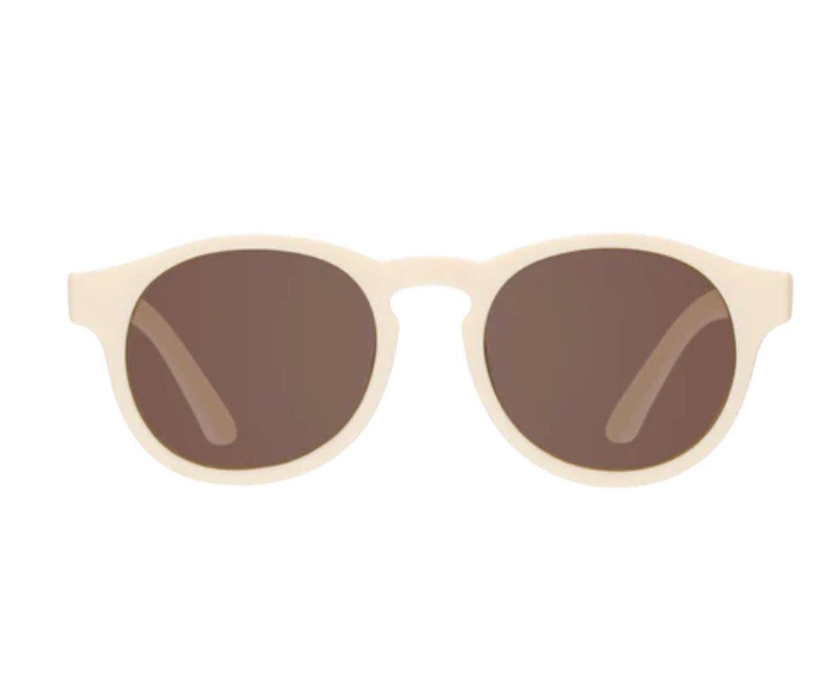 Óculos de sol creme com lentes castanho escuro em fundo branco