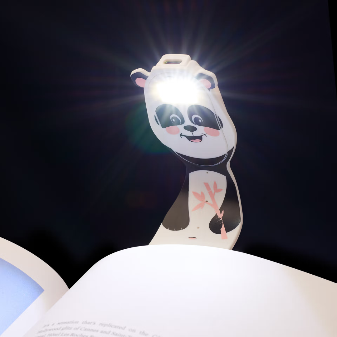 Luz LED de leitura em forma de panda iluminando um livro