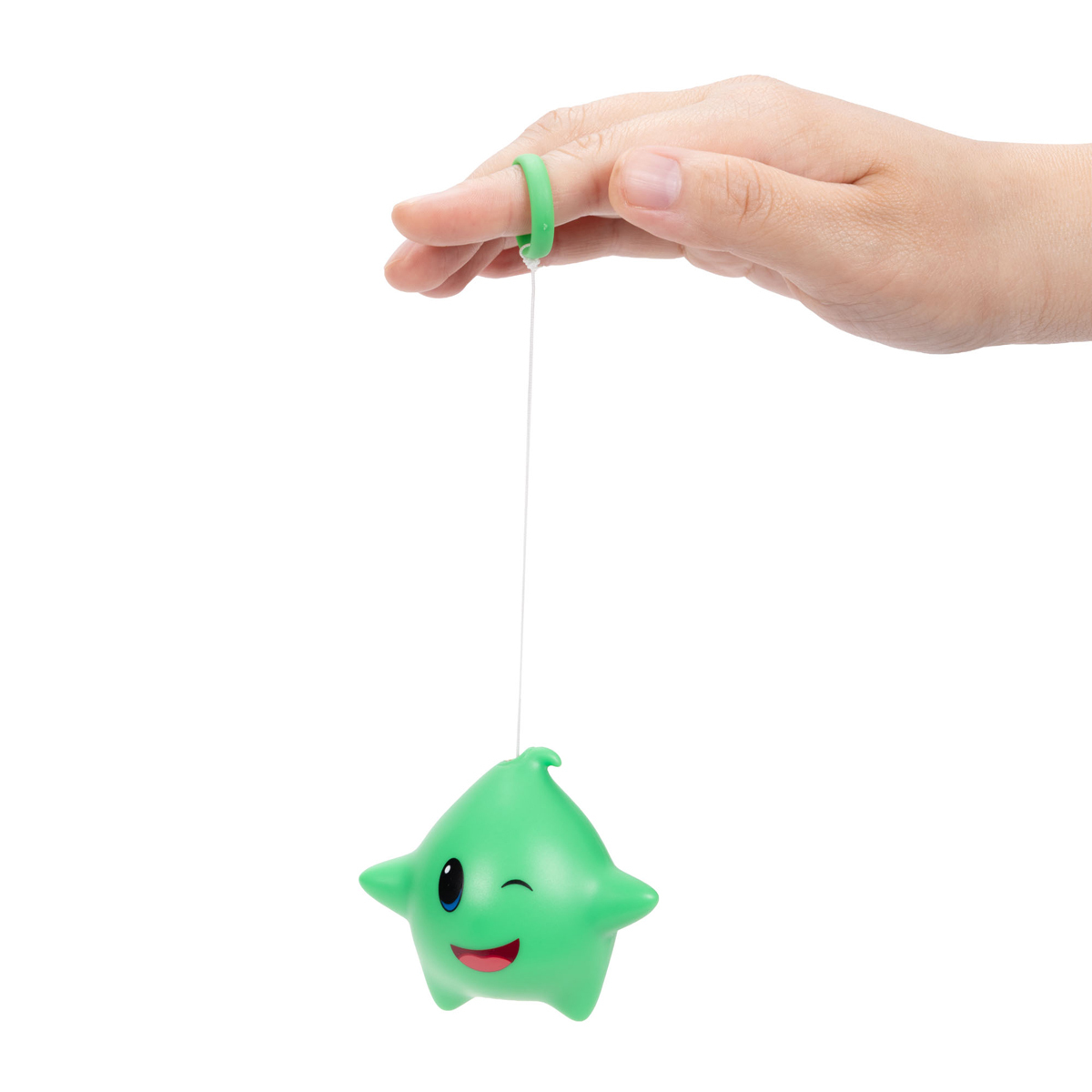 Brinquedo estrela verde pendurado com corda e mão com anel verde