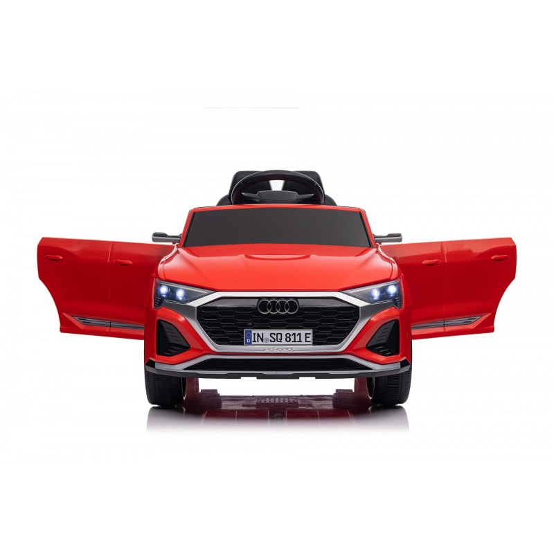 Carro elétrico vermelho infantil com portas abertas e luzes acesas