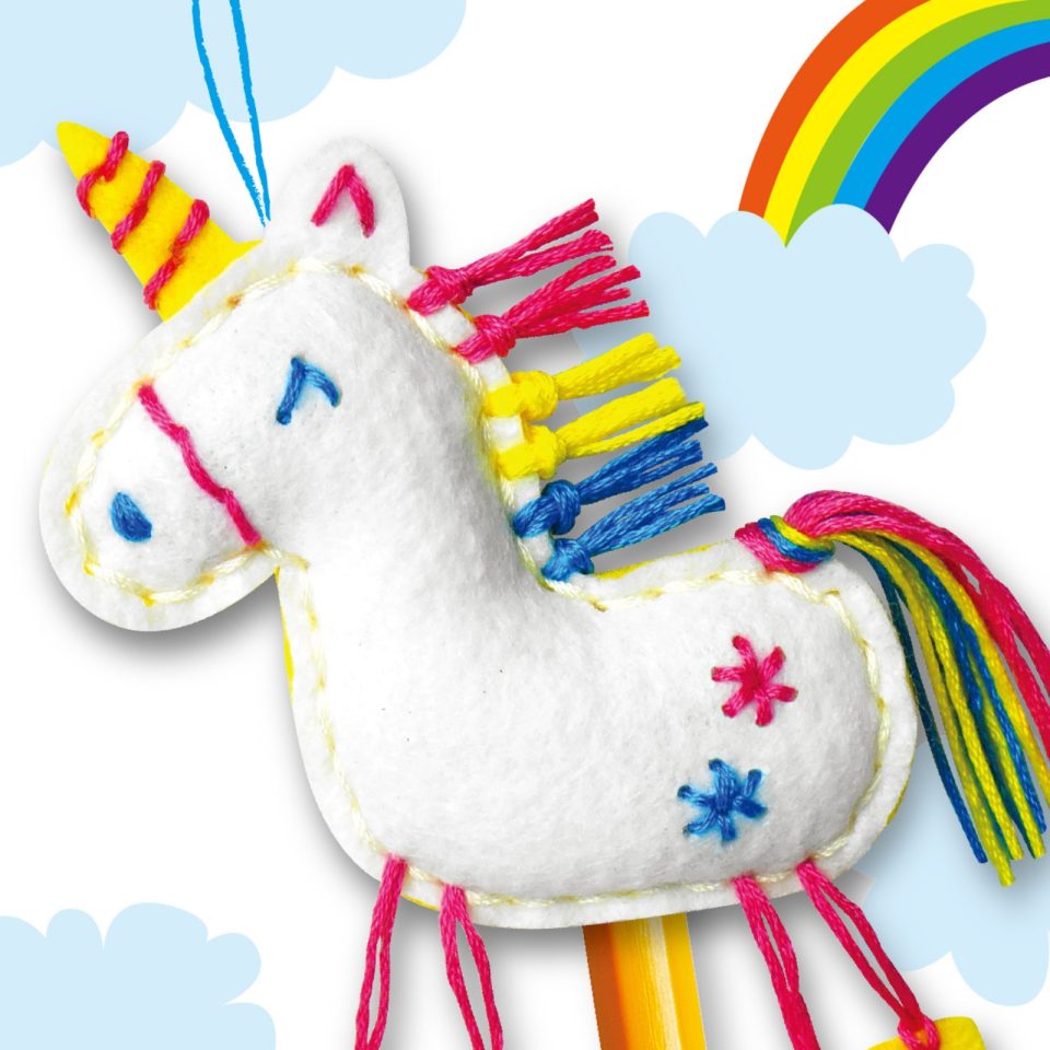 Unicórnio de peluche branco colorido com fundo de arco-íris e nuvens