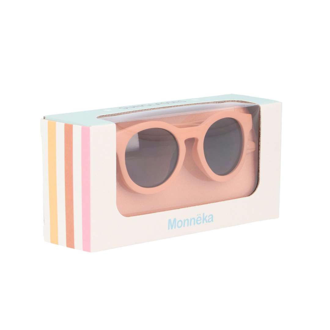 Caixa branca com óculos de sol rosa e lentes redondas escuras
