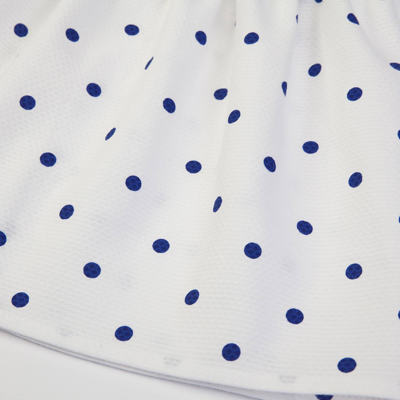 tecido branco com padrão de pontos azuis