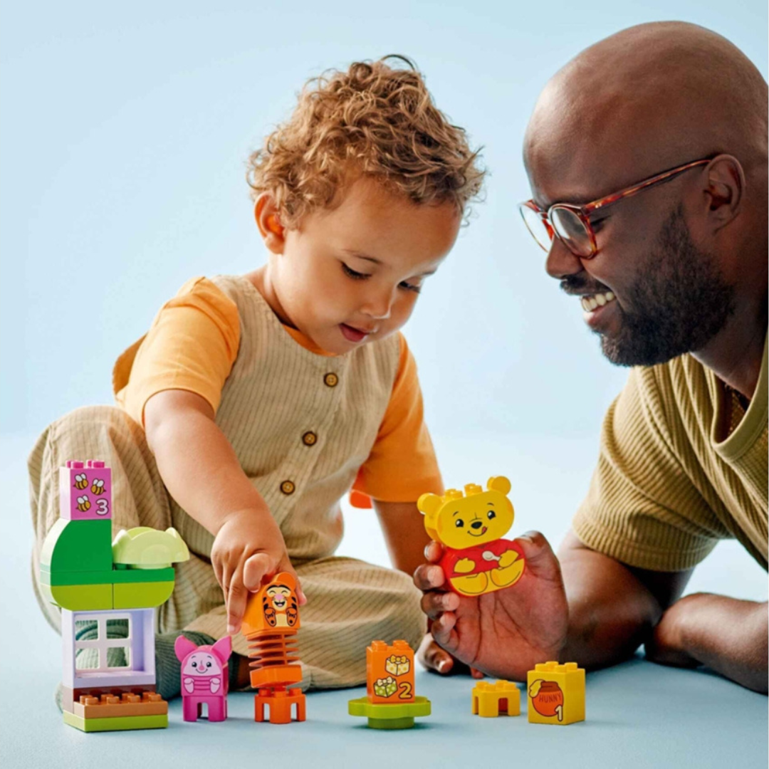 Brinquedos de blocos de construção coloridos com figuras de animais e números sobre superfície azul
