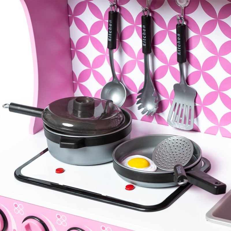 Estufa de brinquedo rosa com panelas pretas e utensílios pendurados