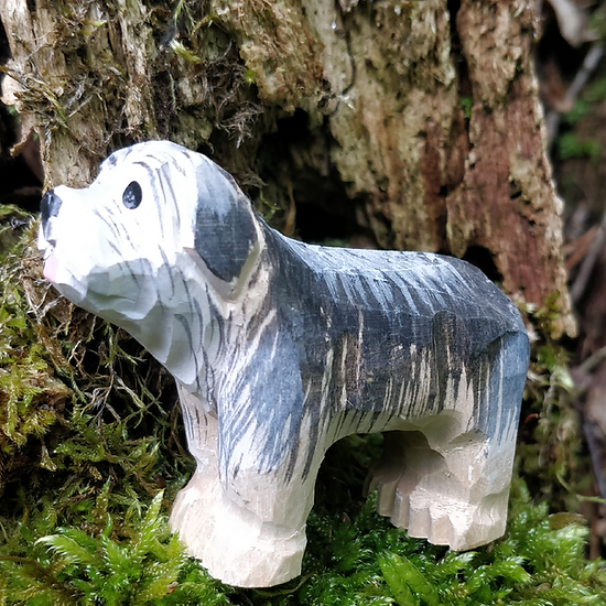 Figura de cão esculpida e pintada em madeira com tons cinza, branco e preto