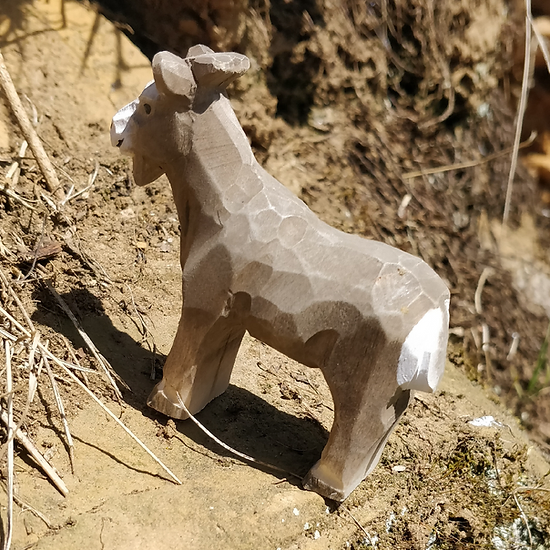 estátua de madeira de cabra castanha com manchas brancas