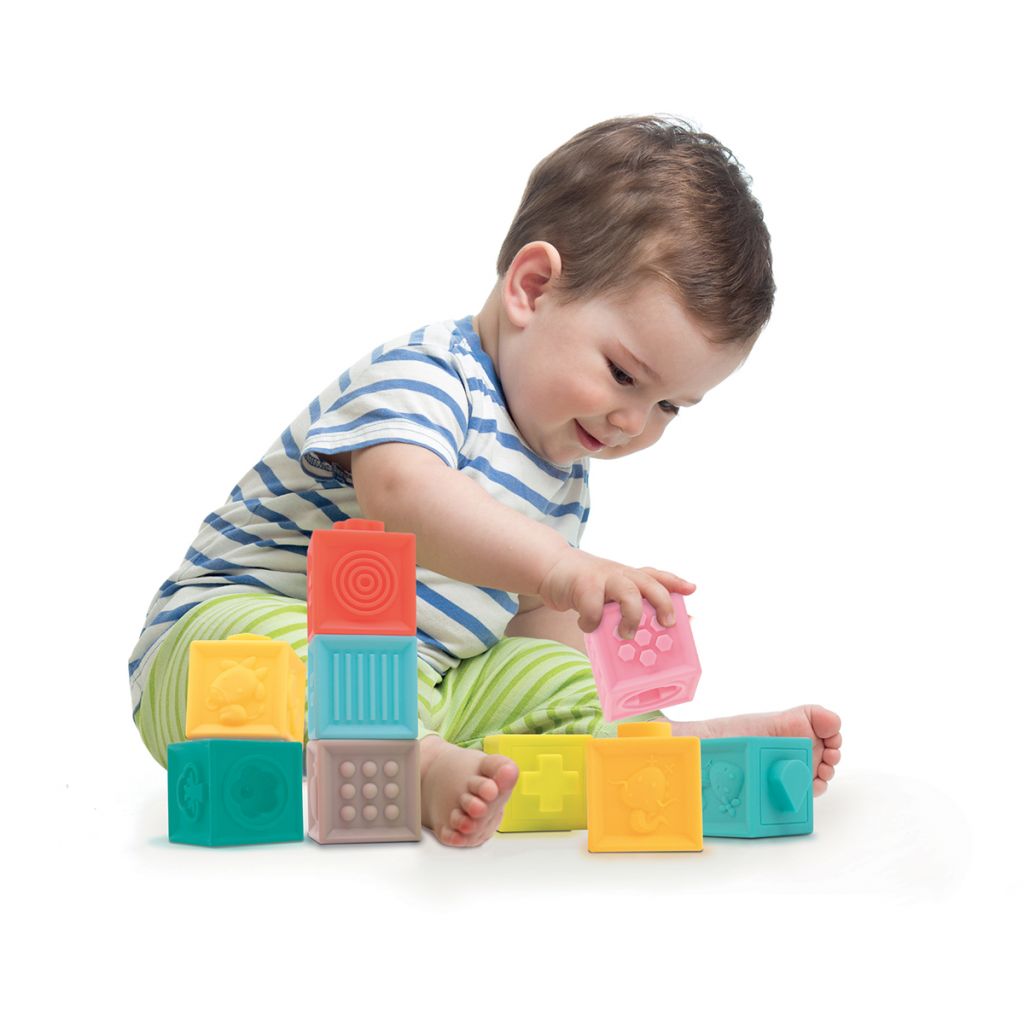 Bebé a brincar com cubos coloridos em fundo branco