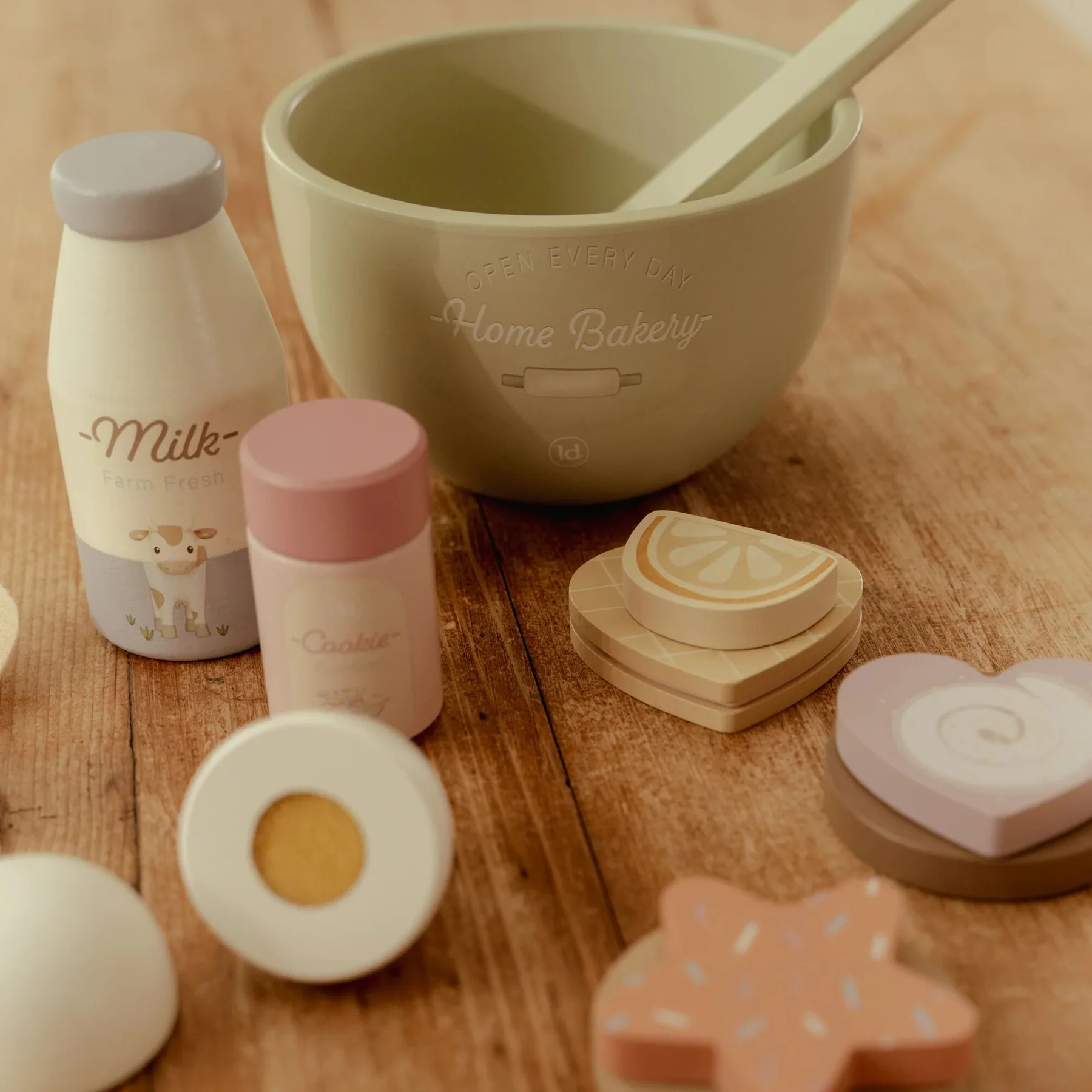 Conjunto infantil de brinquedos em madeira com tema culinário em cores pastel sobre mesa de madeira