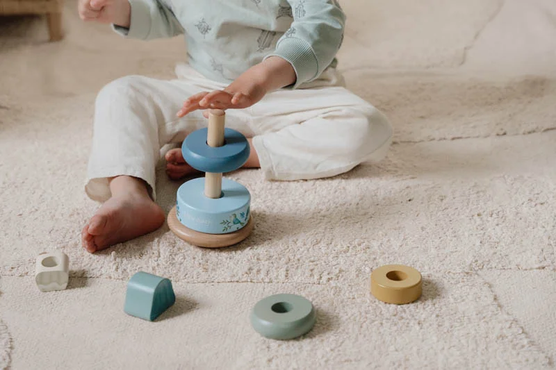 Brinquedo de empilhar em madeira com peças coloridas azuis, amarelas e verdes