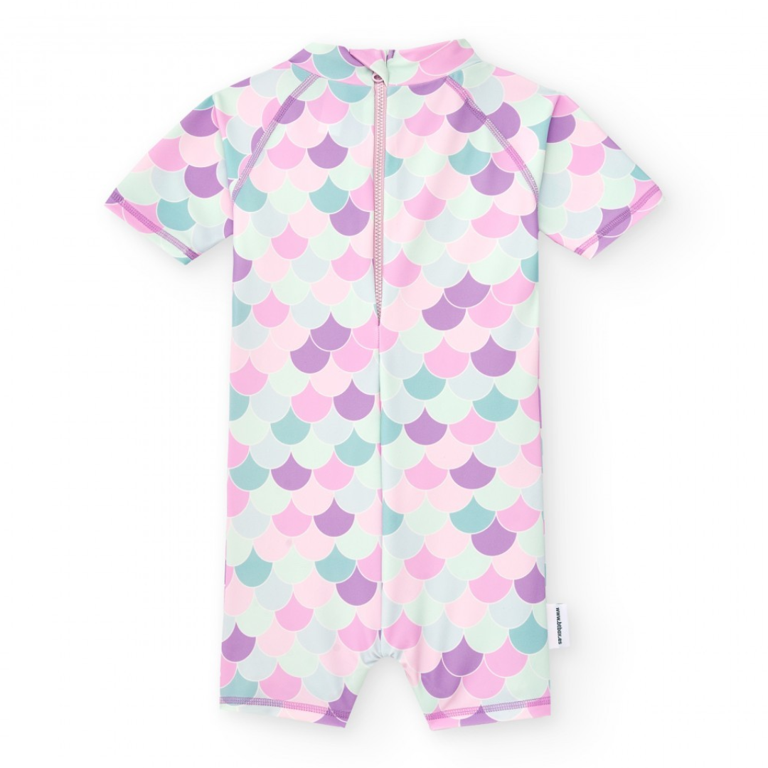 Fato de banho infantil com padrão de escamas em tons pastel e fecho à frente.