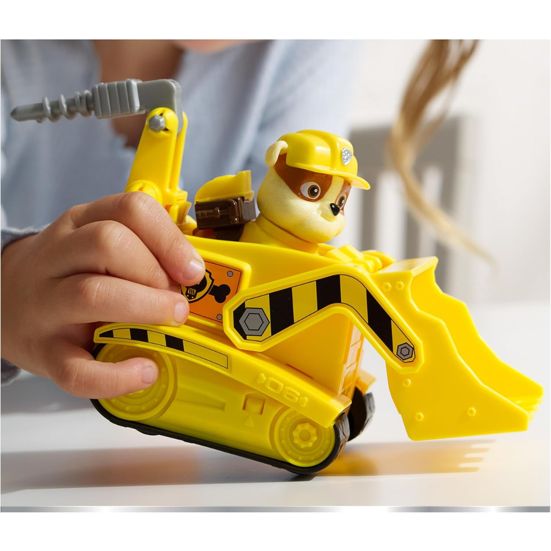 Brinquedo de cão com veículo de construção amarelo nas mãos de uma criança