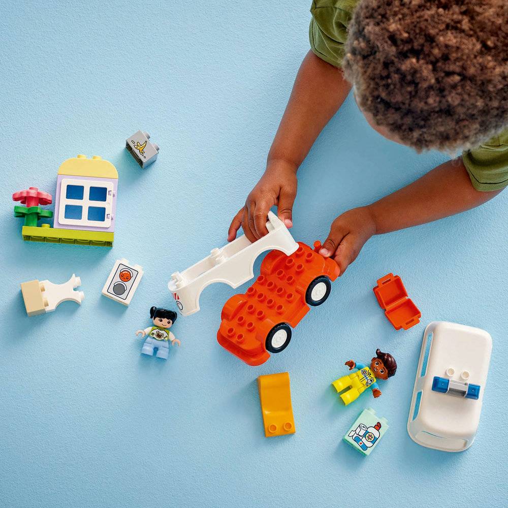 Criança a brincar com blocos de construção tipo LEGO e mini-figuras coloridas