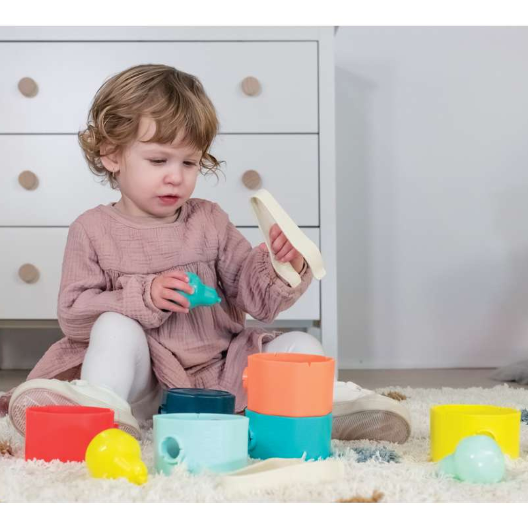 Criança sentada a brincar com blocos coloridos no chão