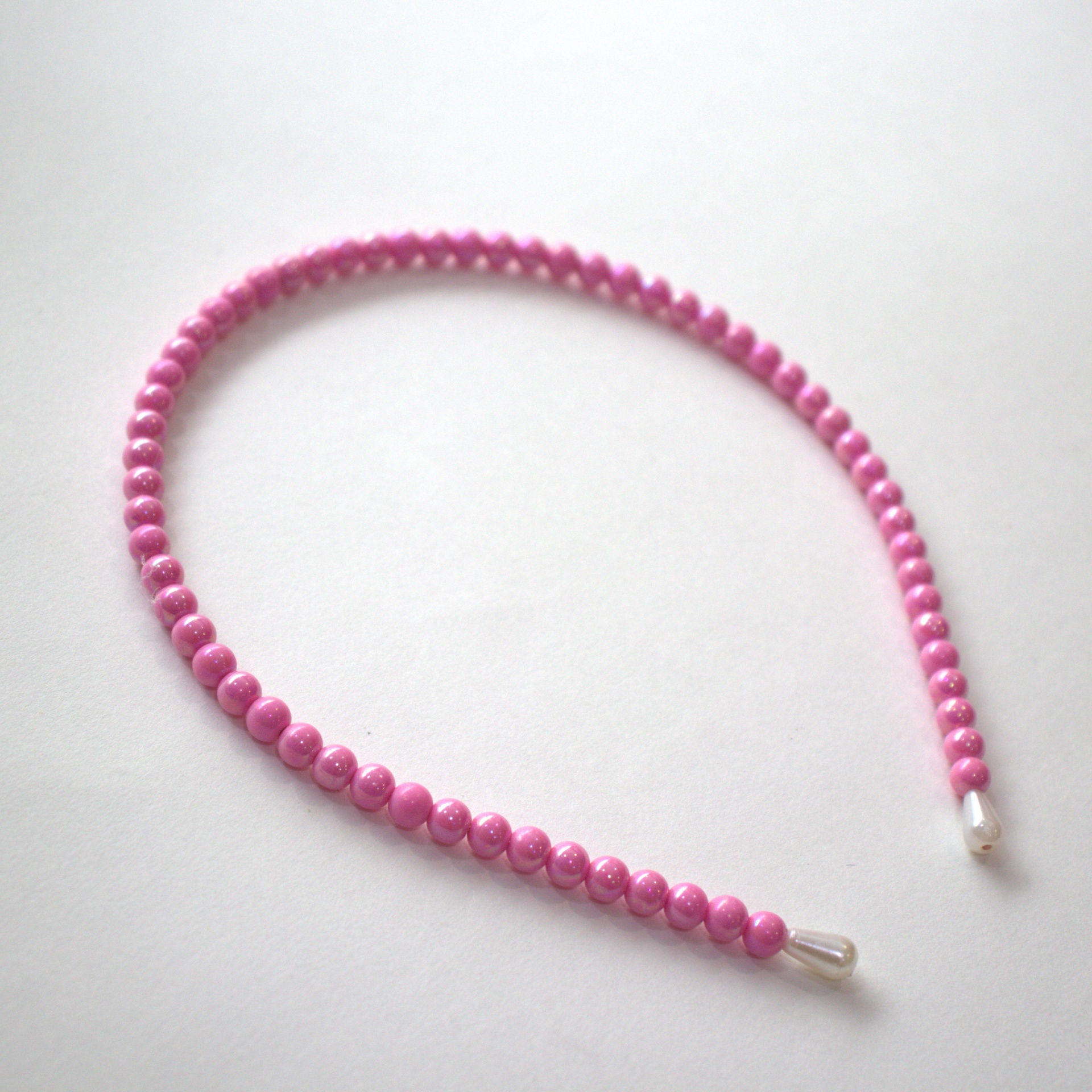 Tiara rosa de contas redondas sobre fundo branco