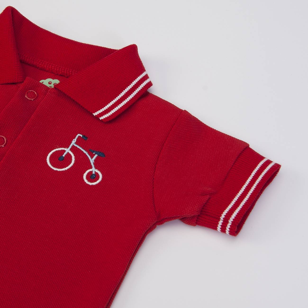 Polo infantil vermelho com bordado de bicicleta e riscas brancas na gola e punhos