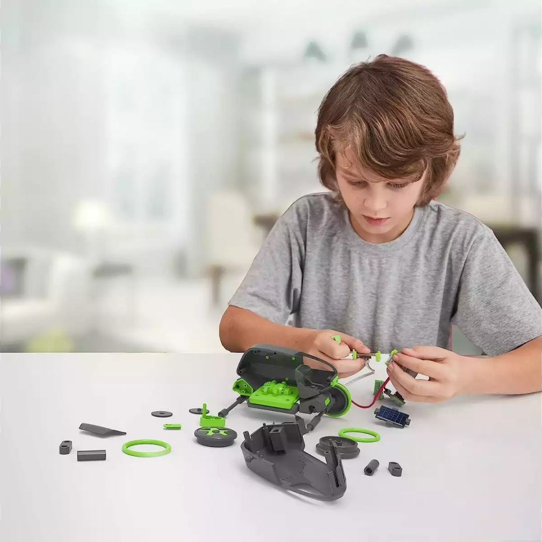 Criança a montar robô de brinquedo verde e cinzento num ambiente interior