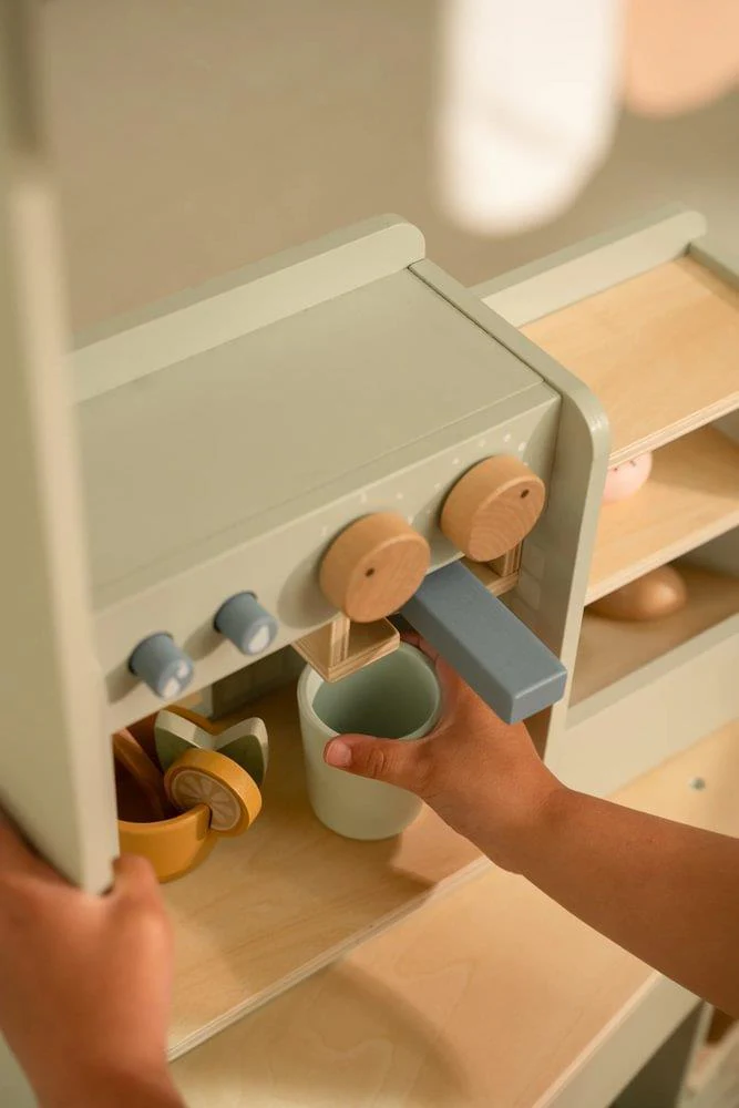 Máquina de café de madeira e copos coloridos com mãos infantis