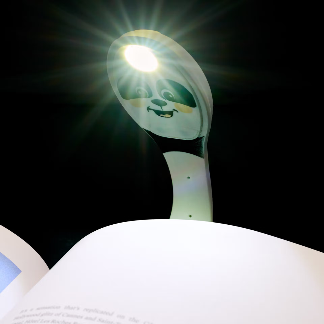 Lâmpada LED com suporte decorativo de panda iluminando um livro aberto