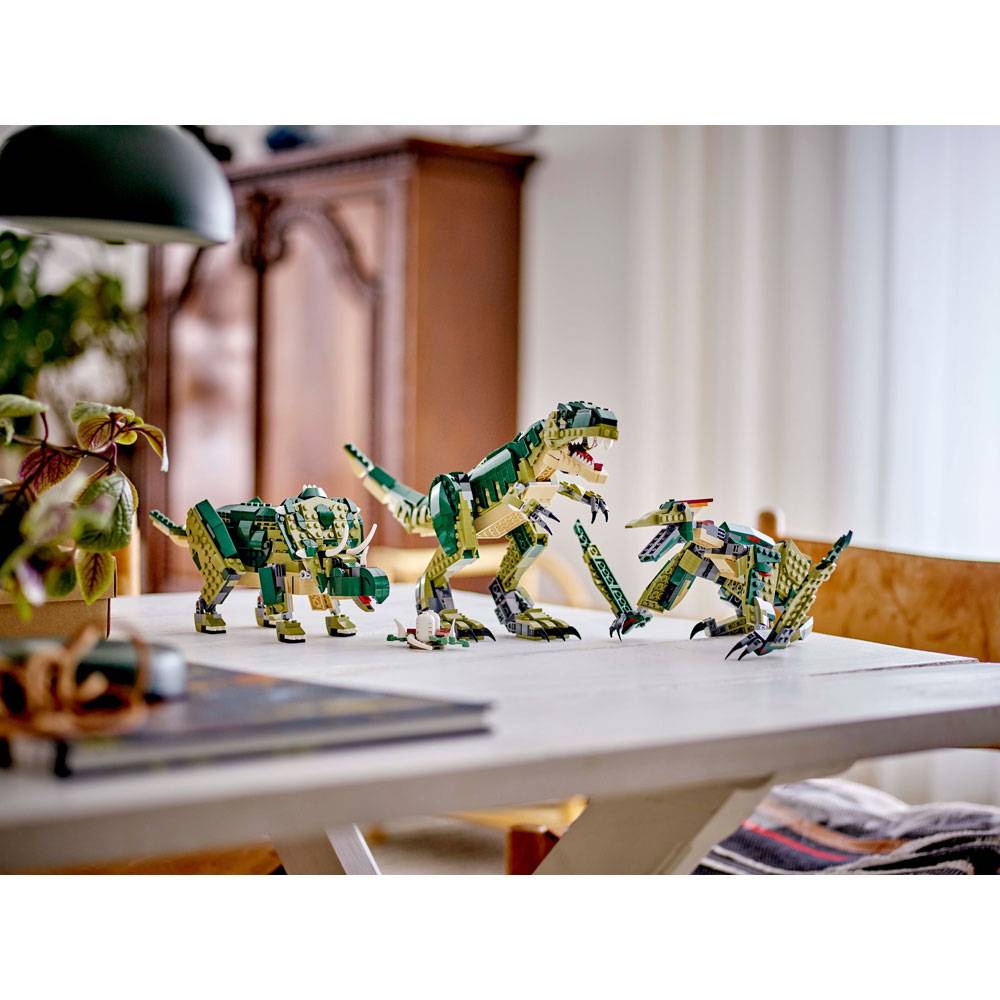 Figuras de dinossauros verdes em blocos de construção sobre uma mesa branca
