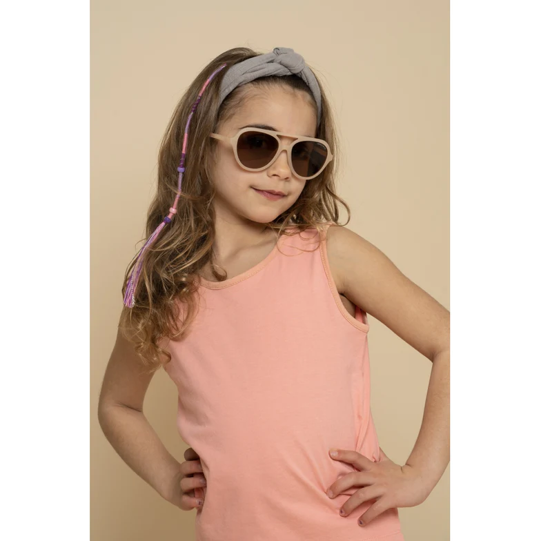 Menina com camisola rosa, óculos de sol bege e faixa de cabelo gris