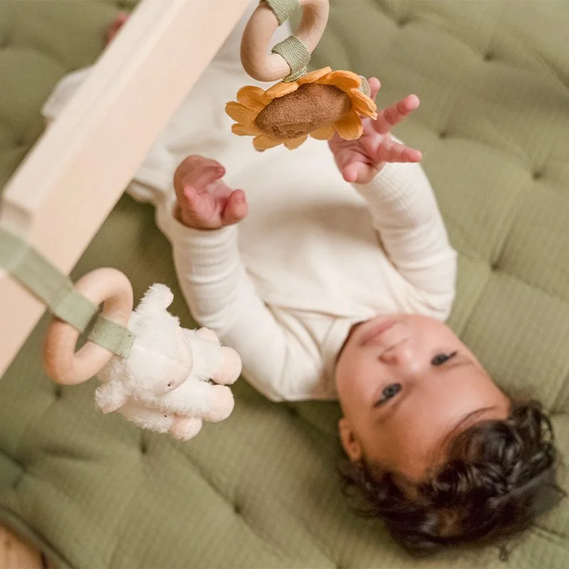 Brinquedo pendurado de madeira e tecido com figuras macias de girassol e animal branco