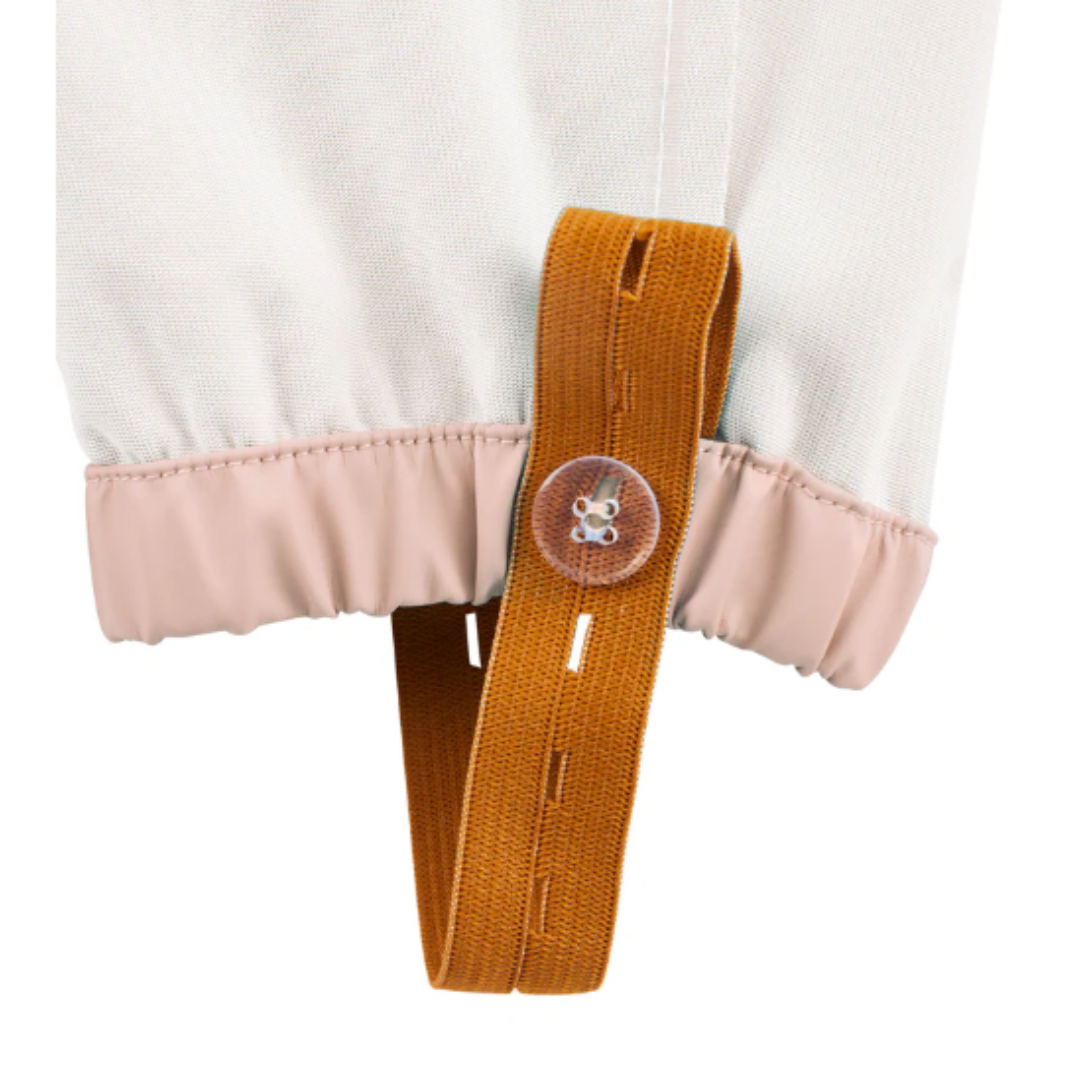 Detalhe de bainha elástica rosa clara com alça castanha e botão transparente