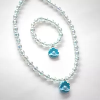 Conjunto de bijuteria com colar e pulseira de contas transparentes com pendentes de conchas azuis e pérolas brancas.